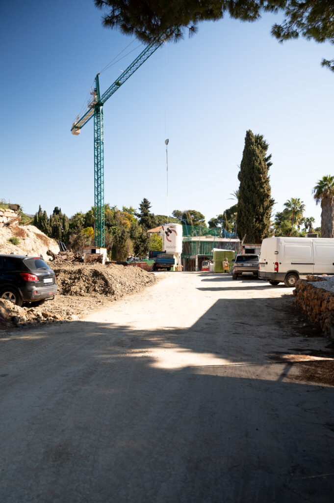 A view from our project management office in Marbella. A dirt road leads towards a crane in the distance.